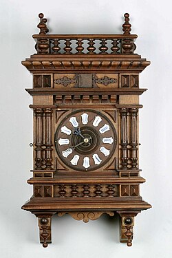 A neo-Renaissance example, dial with cartouches of Roman numerals, c. 1890 (Deutsches Uhrenmuseum, Inv. 09–3936)