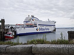Large roll-on/roll-off ferry MV Armorique (Brittany Ferries) berthed at a port with a small service boat alongside.