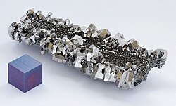 Niobium crystals and a 1 cm3 anodized niobium cube for comparison
