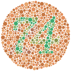 The number "74" – composed of scattered solid circles of varying size and varying but approximately green color – surrounded by a field of approximately sandy brown circles also of varying size and color. Some of the color variation in the circles is deliberately curated such that viewers with red-green color blindness will likely see the number "21" instead of "74".