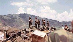 A group of officers in field gear standing in the middle of a base.